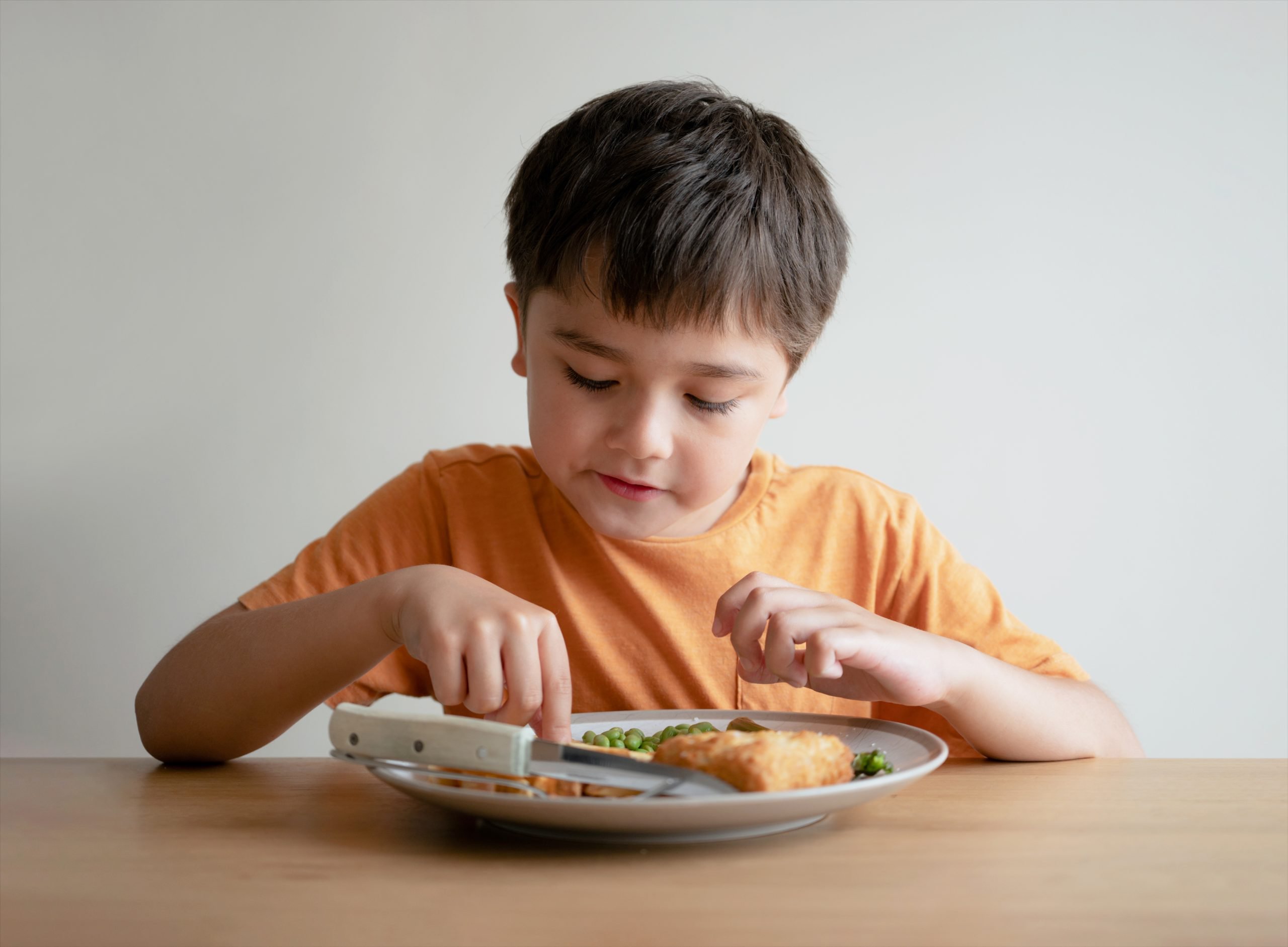 A young boy eating homemade fish fingers and chips